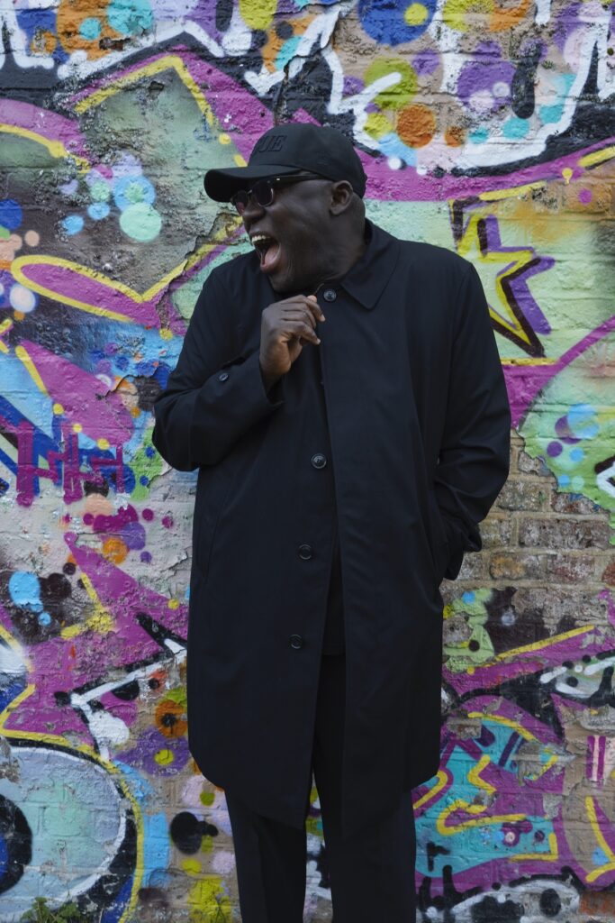 Edward Enninful poses in front of graffiti