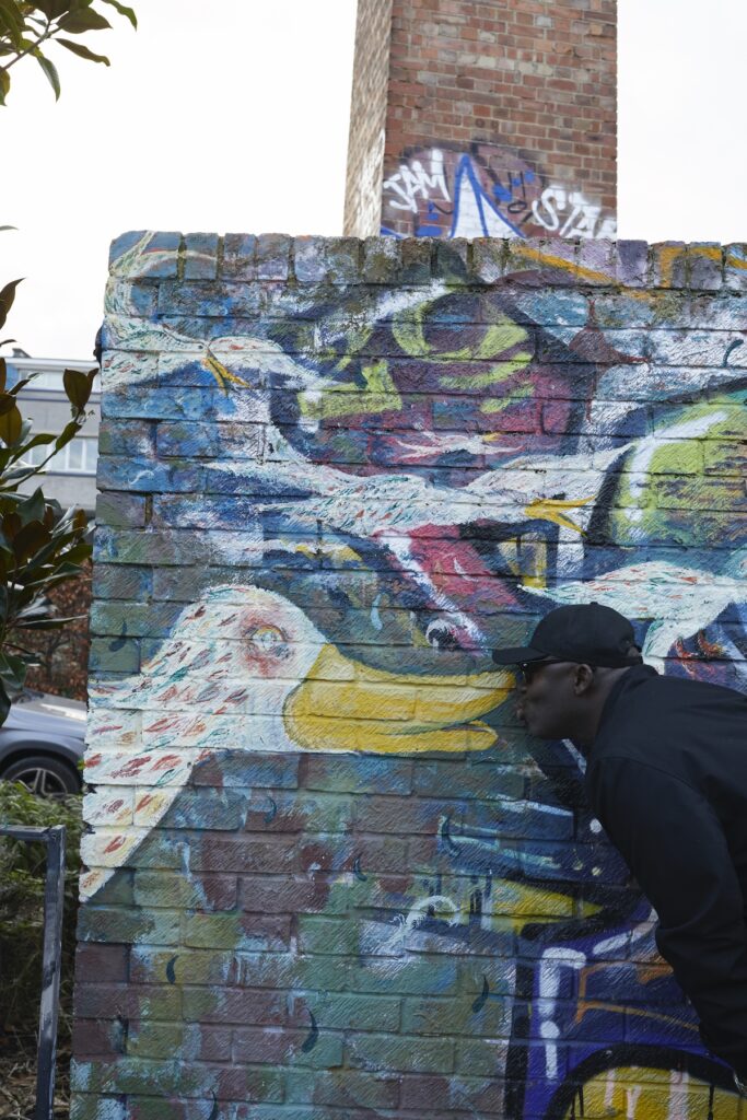 Edward Enninful kisses a graffiti duck on a wall in Ladbroke Grove in London