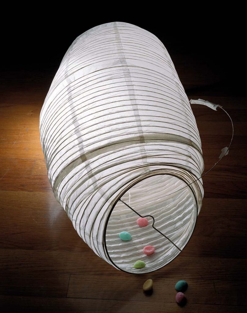 Expandable lampshade lies on its side, with small candy inside it