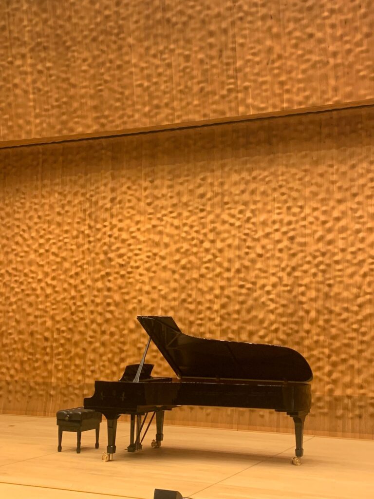 Grand piano against textured wall in Hamburg's Philharmonie