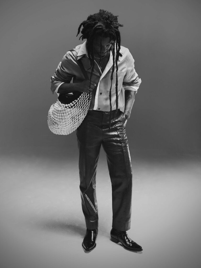 Black and white, full-length shot of Akinola wearing Bottega