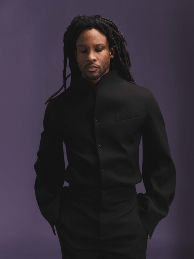 Akinola looks sleek in a Bottega black collarless wool suit