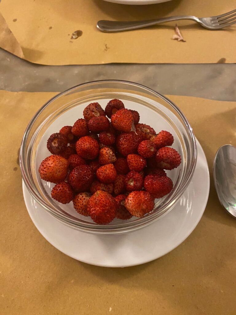 Photograph of wild strawberries in a clear bowl