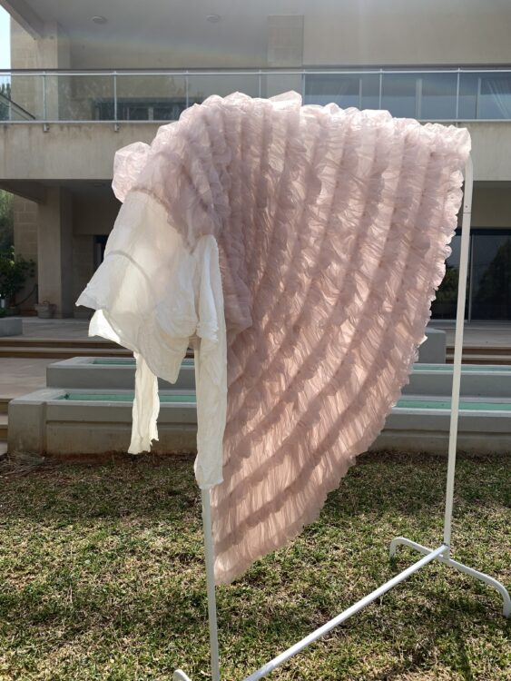 Photo of a pink dress lying in the sunny outdoors on a clothes rail