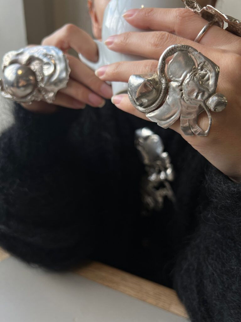 Close-up of enormous, decadent silver rings